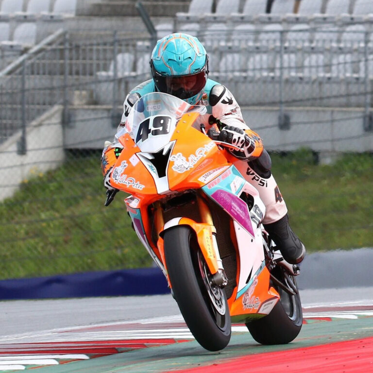 Motorradfahrer auf orangenem Superbike BMW-S1000RR am Redbullring im Jahr 2017.