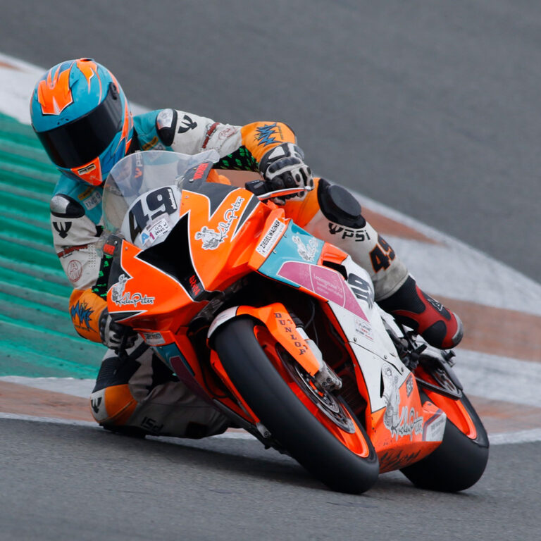 Motorradfahrer auf Superbike knieschleifend in der Kurve.